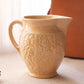 Medium Tan Ceramic Pitcher with Floral Details