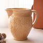 Medium Tan Ceramic Pitcher with Floral Details